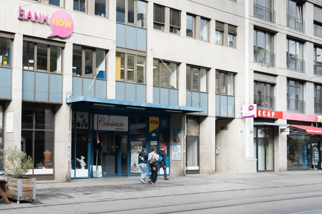 Aussenansicht der BANK-now Filiale Basel mit Eingang und Strassenfront.